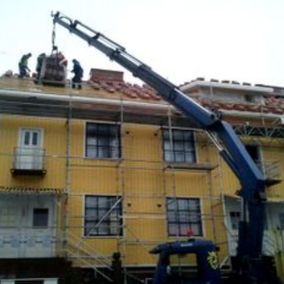 Nosturi nostaa rakennustarvikkeita saneerattavan talon katolle